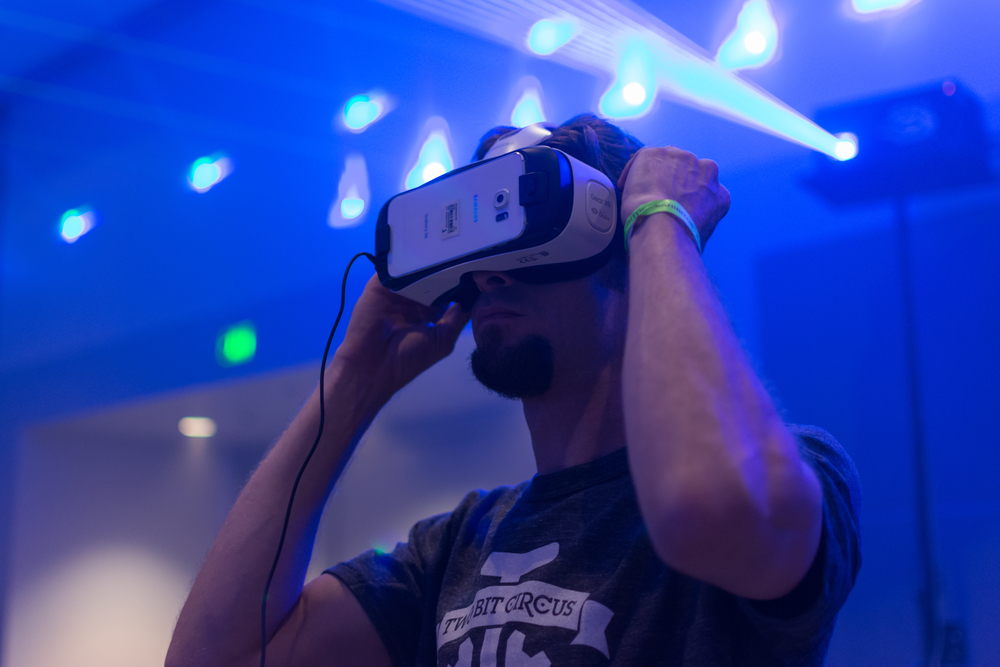 Guy tries virtual glasses headset during VRLA Expo, virtual reality exposition, event at the Los Angeles Convention Center in Los Angeles.