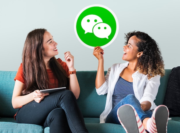 Free photo young women showing a wechat icon